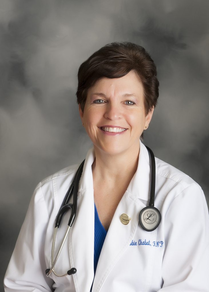 A woman in white coat with stethoscope around neck.