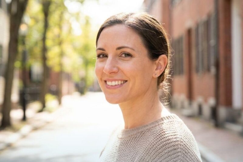 Woman smiling on a sunny street.