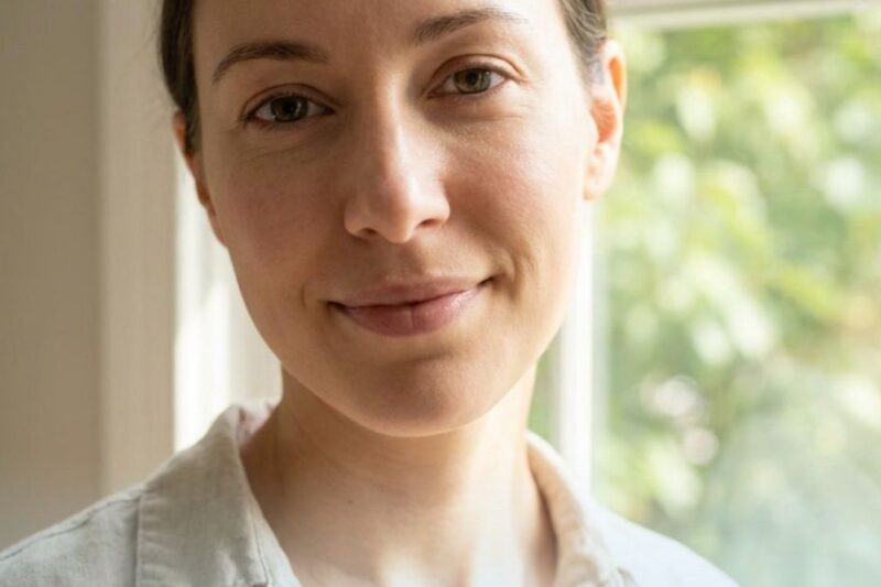 Person smiling near window with text overlay.