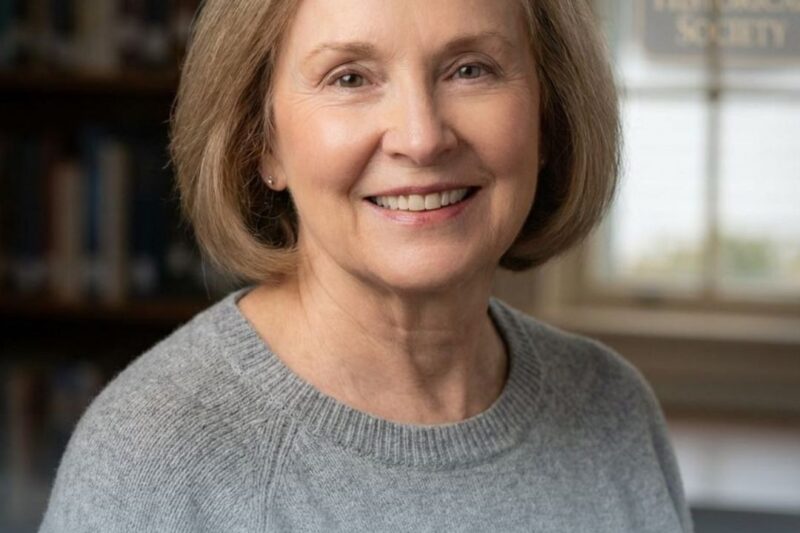 Smiling woman in a cozy sweater indoors.
