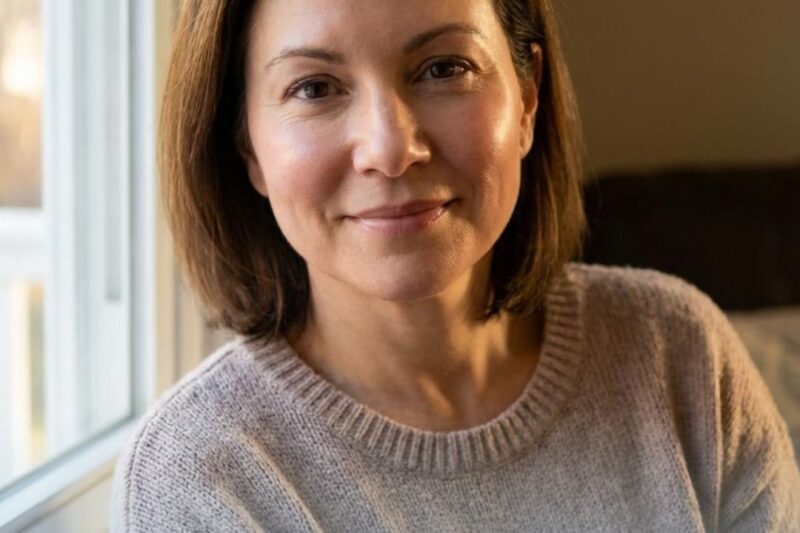 Woman smiling by a window, promotional text.